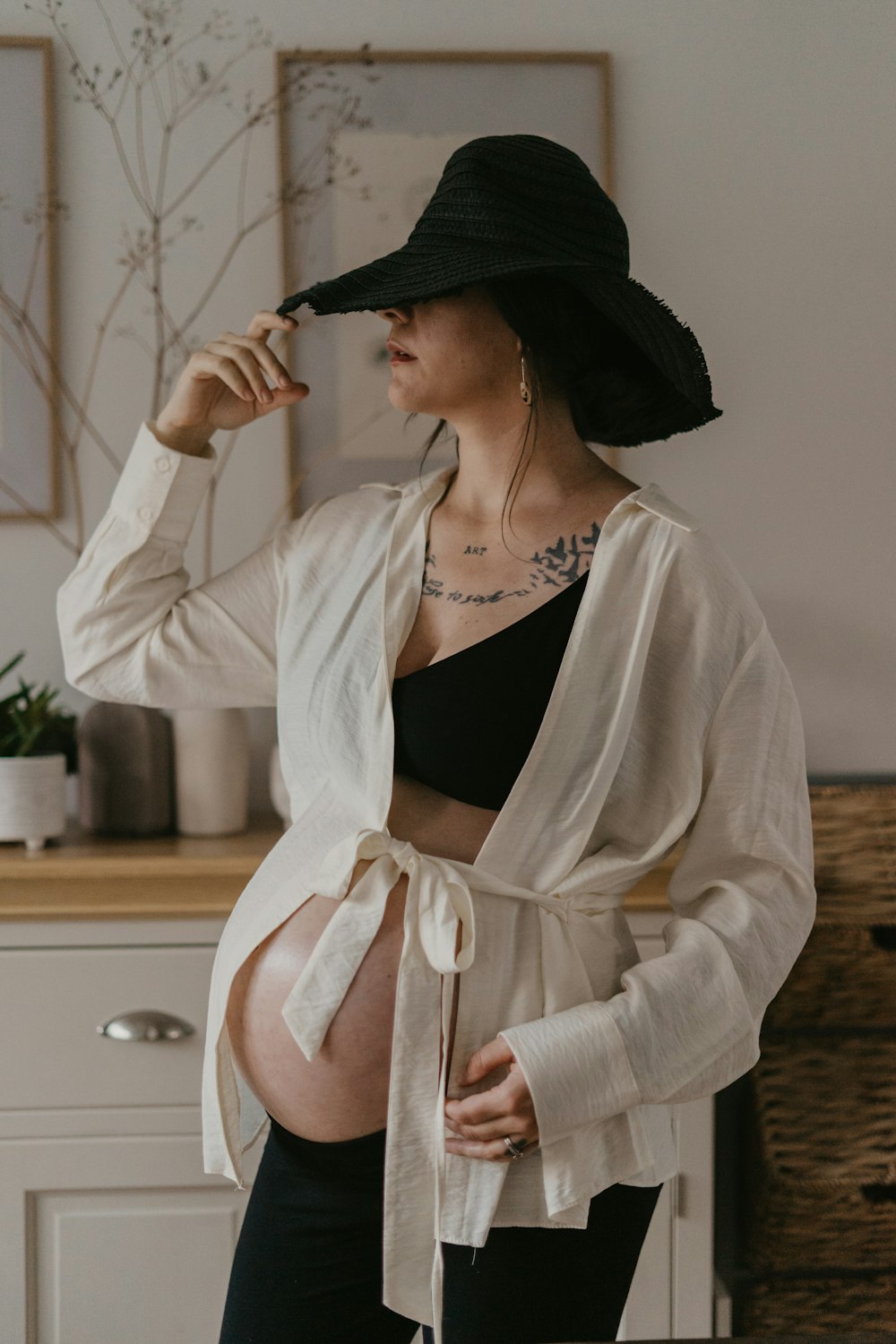 una mujer embarazada con un sombrero negro