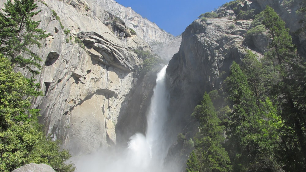 a large waterfall in the middle of a forest