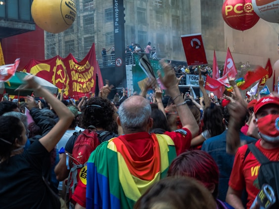 A vibrant rally scene with a crowd cheering and holding banners.