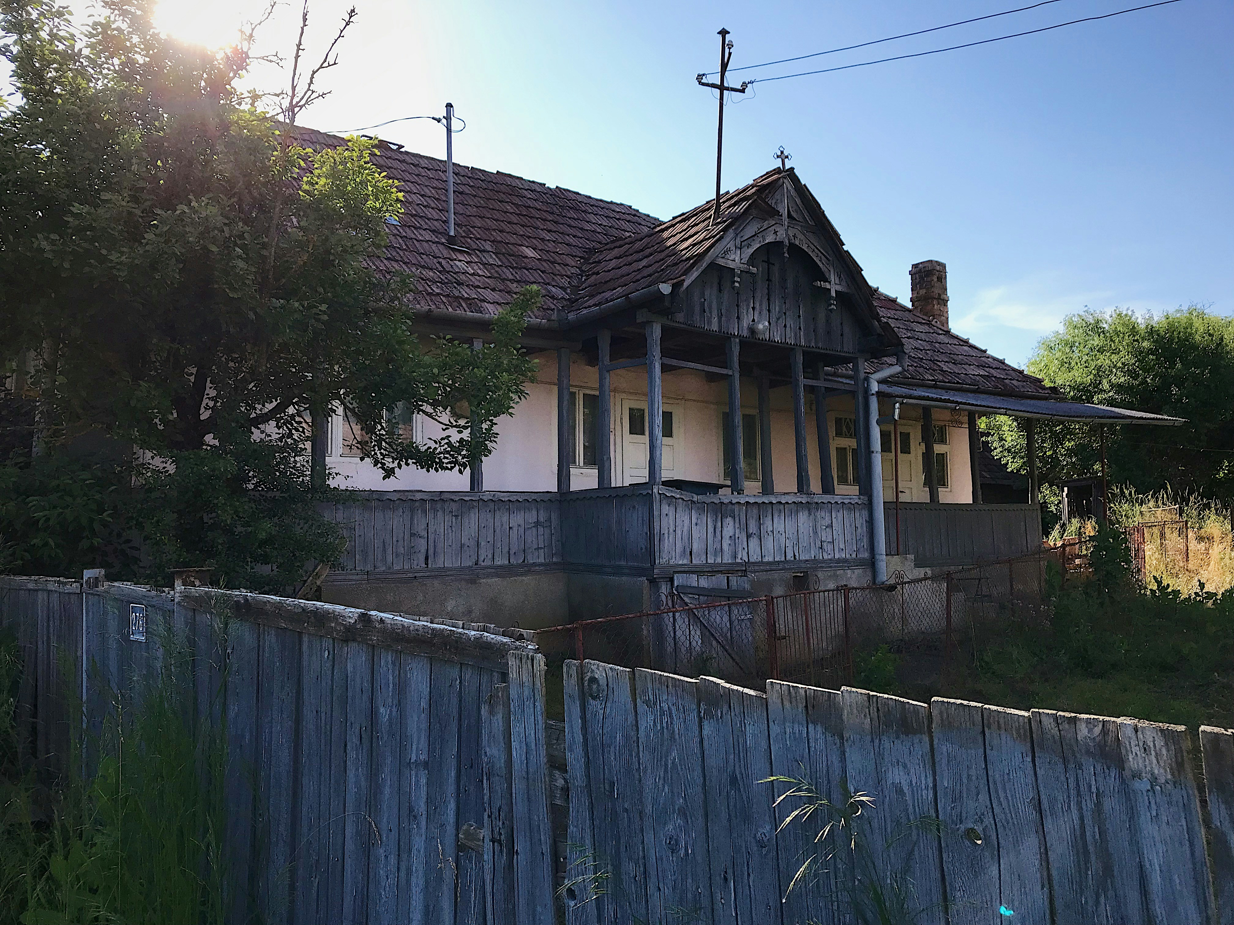 an old run down house with a wooden fence