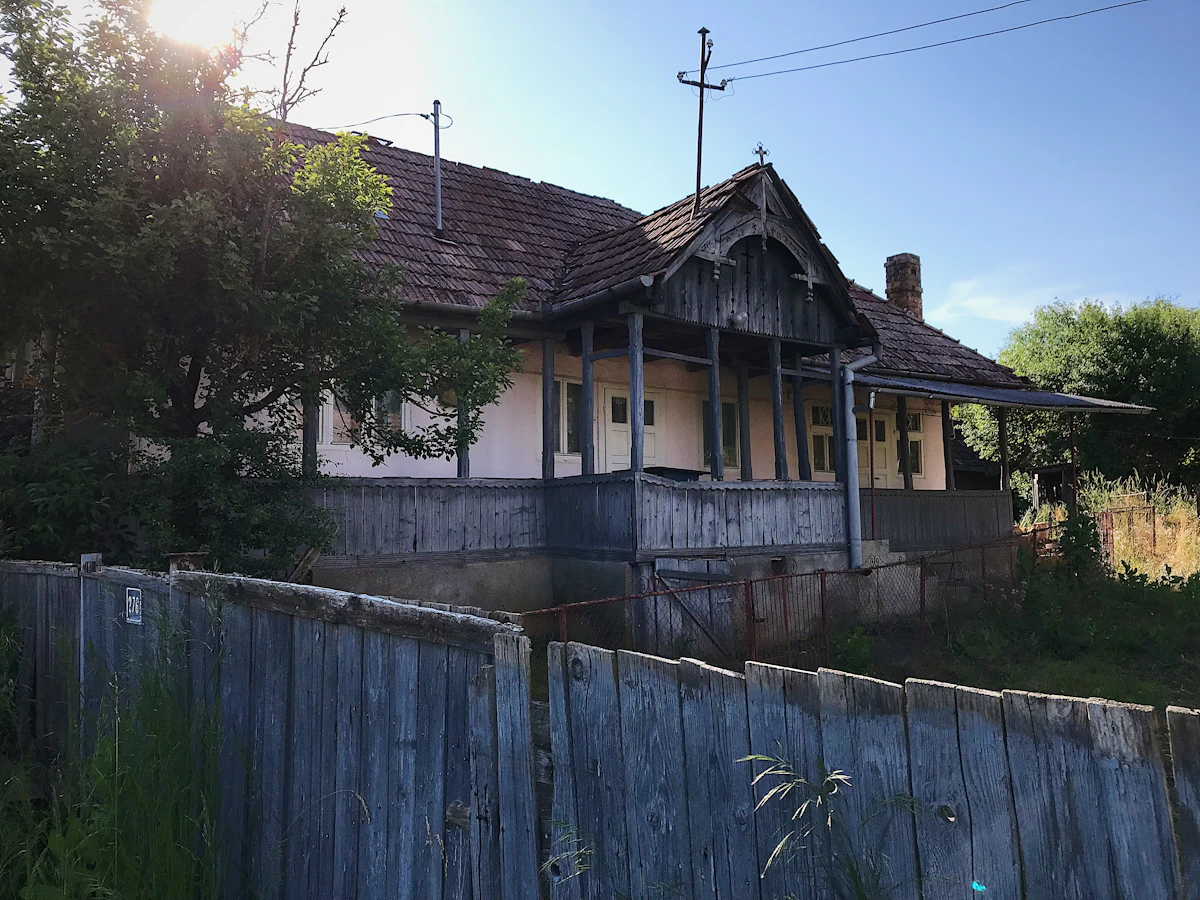 Rumah tua yang bobrok dengan pagar kayu.