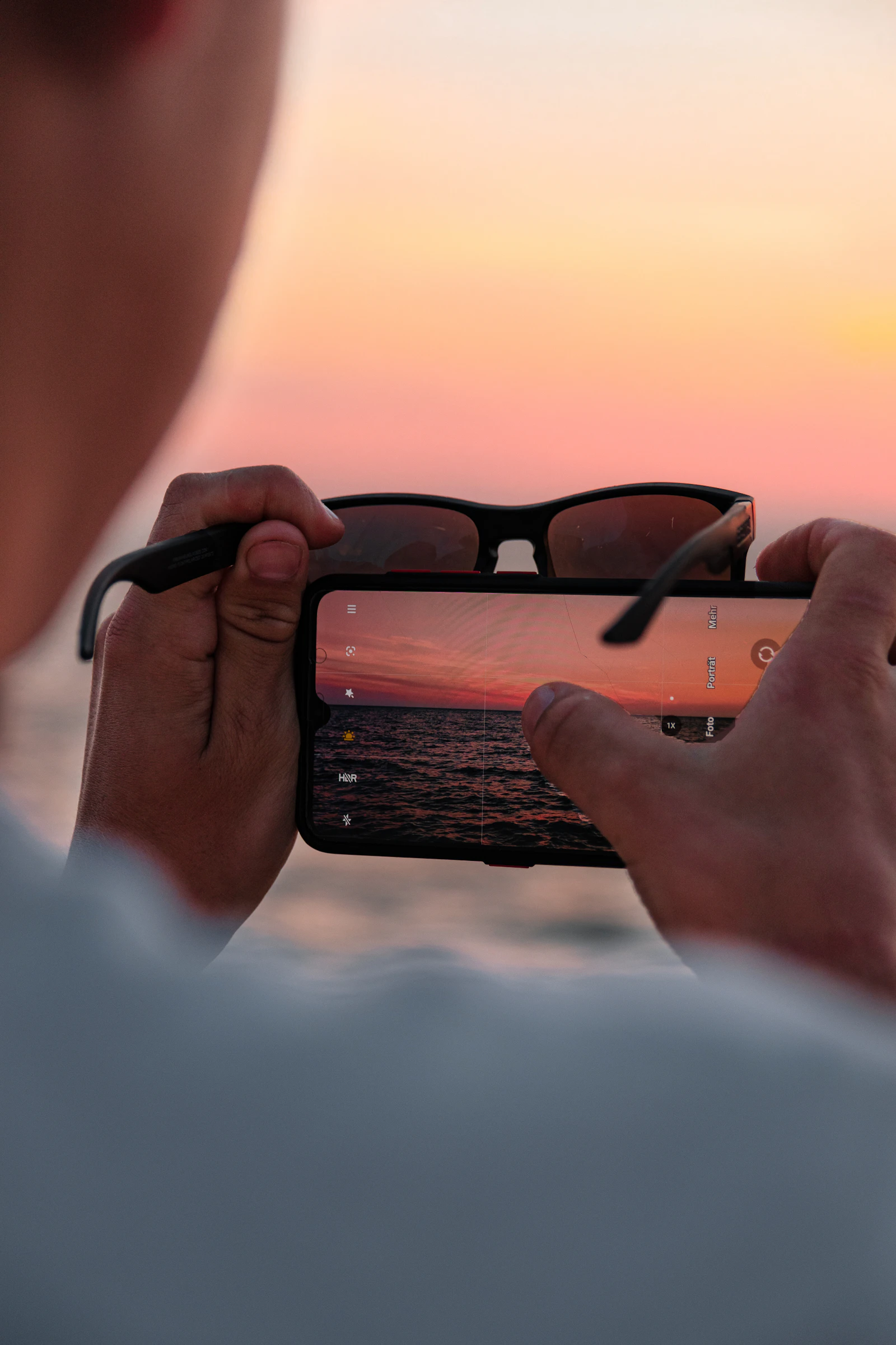 Person holding a smartphone outdoors in direct sunlight