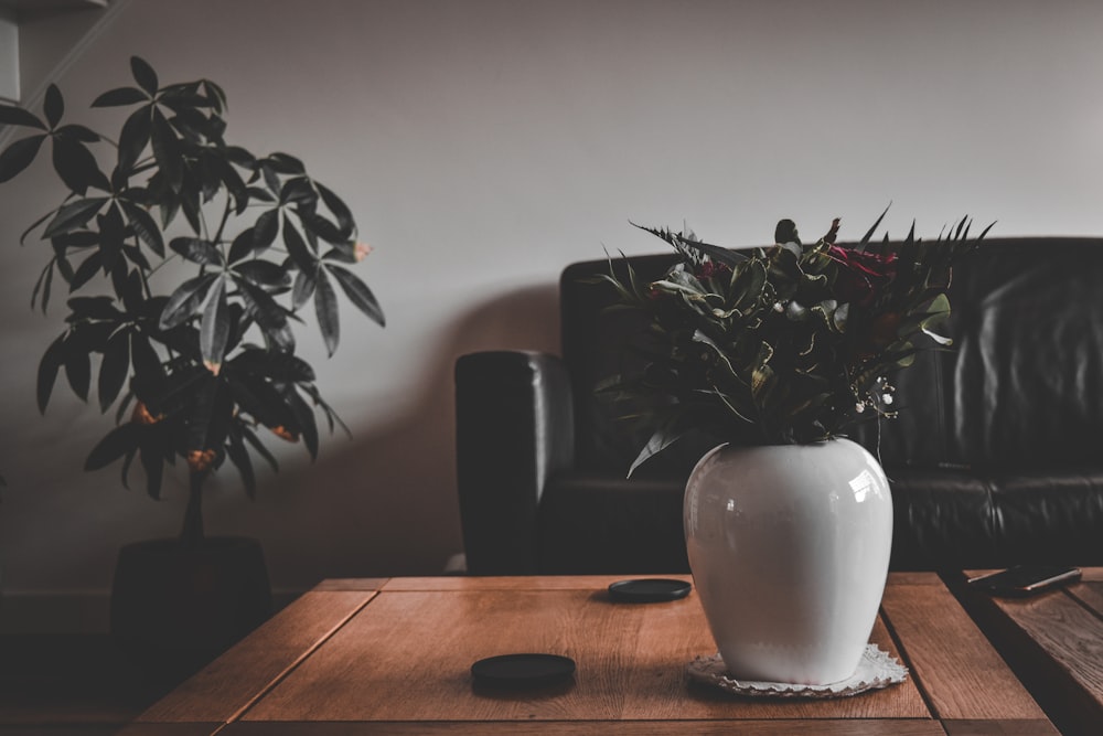 a white vase sitting on top of a wooden table