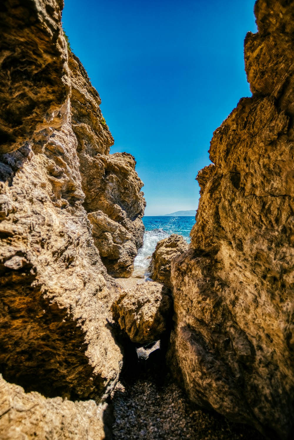 a view of the ocean through some rocks