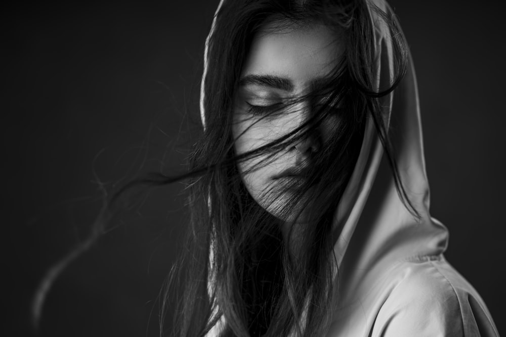 uma foto em preto e branco de uma mulher com os olhos fechados