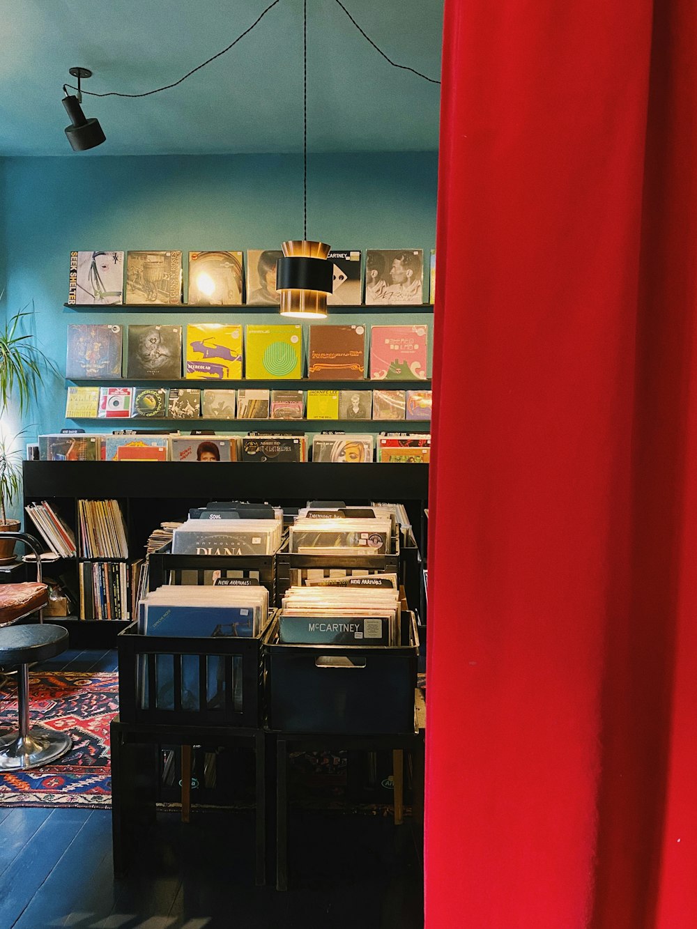 a room filled with lots of records and a red curtain