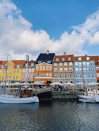 a group of boats parked in front of a row of buildings