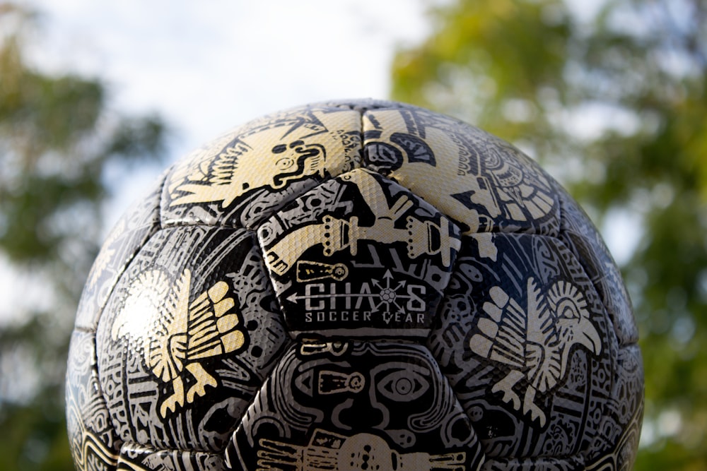 a close up of a soccer ball with a tree in the background