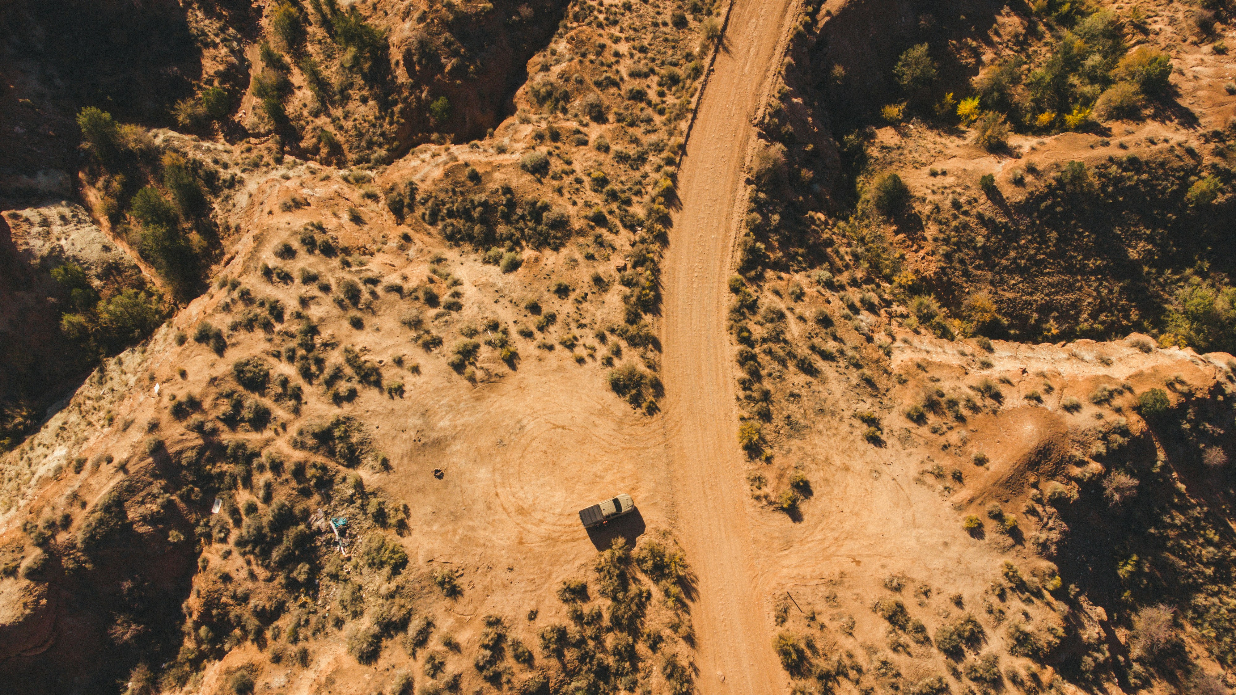 an aerial view of a dirt road in the desert
