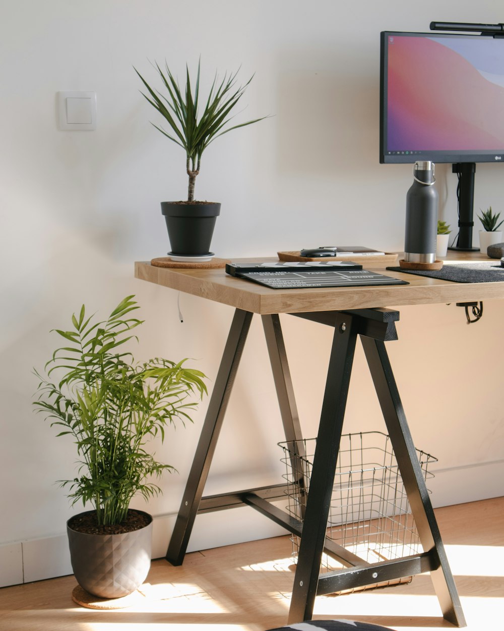 a wooden desk with a computer monitor and keyboard