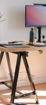 a wooden desk with a computer monitor and keyboard