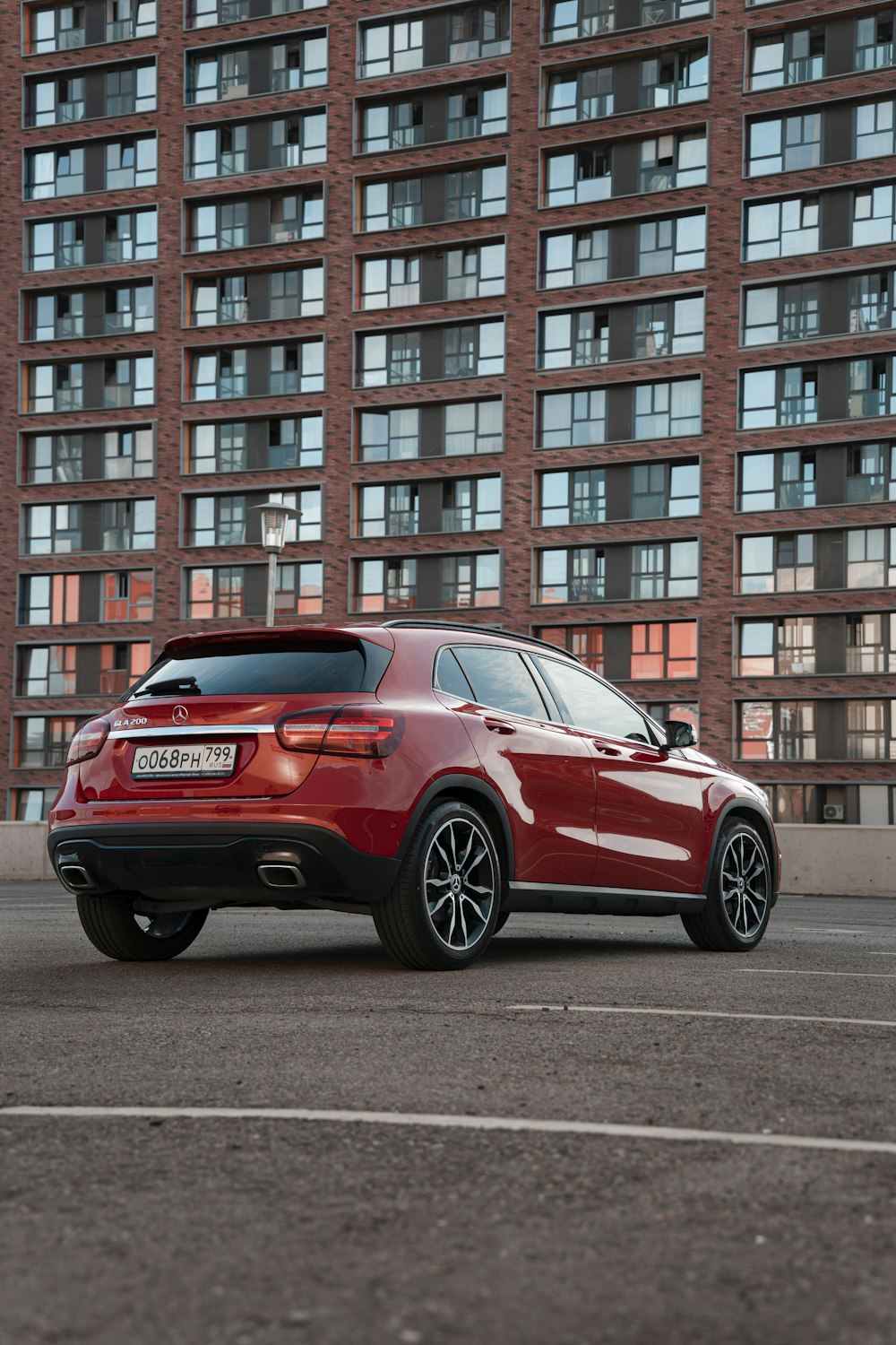 a red car parked in front of a tall building