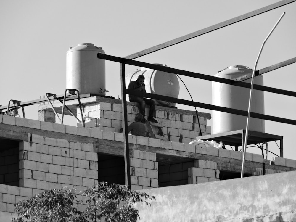 a black and white photo of a man on a roof
