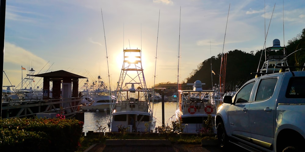the sun is setting over the boats in the harbor