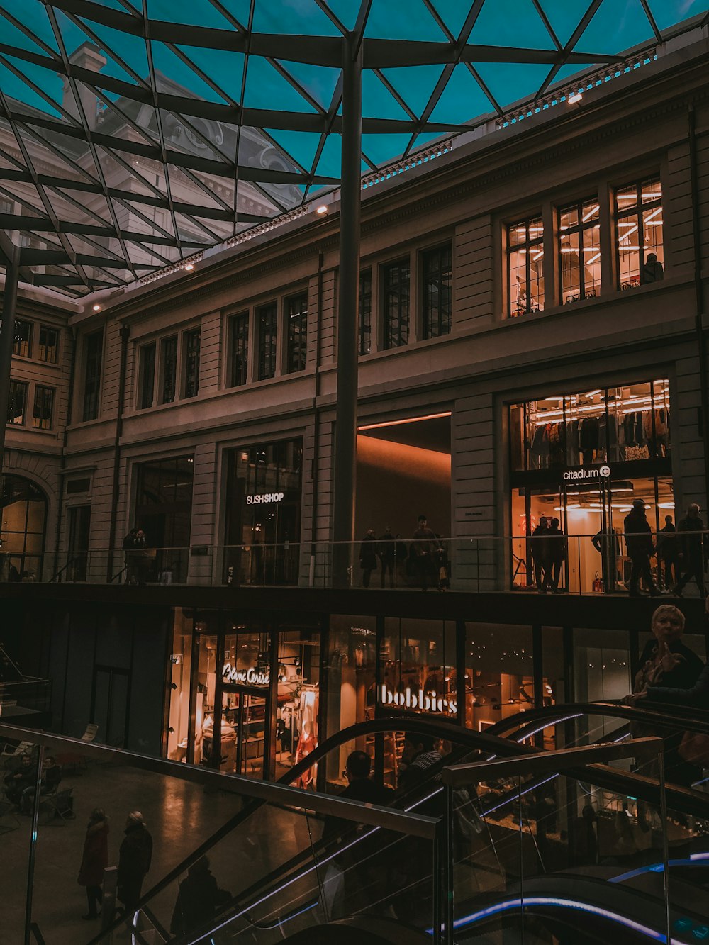 a group of people walking around a shopping mall