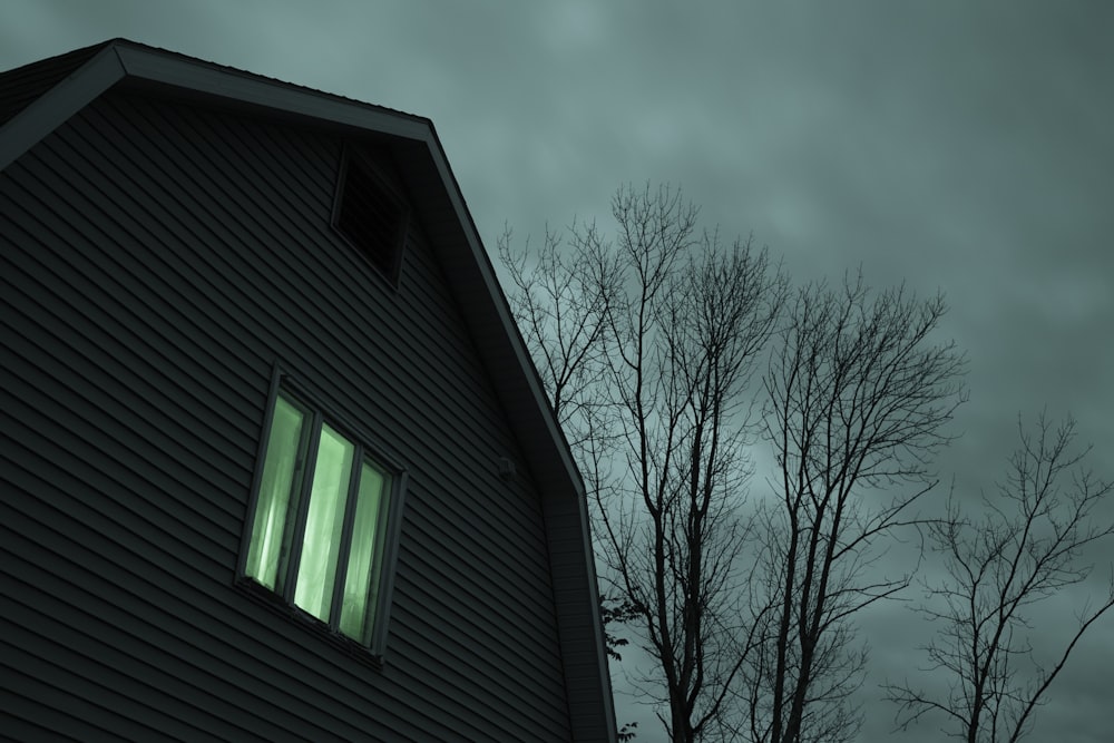 a black house with a green light in the window