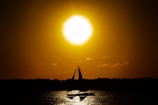 Sunset view over the horizon with a silhouette of a sailing yacht