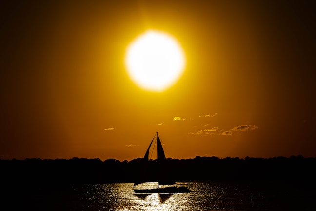 Sunset view over the horizon with a silhouette of a sailing yacht
