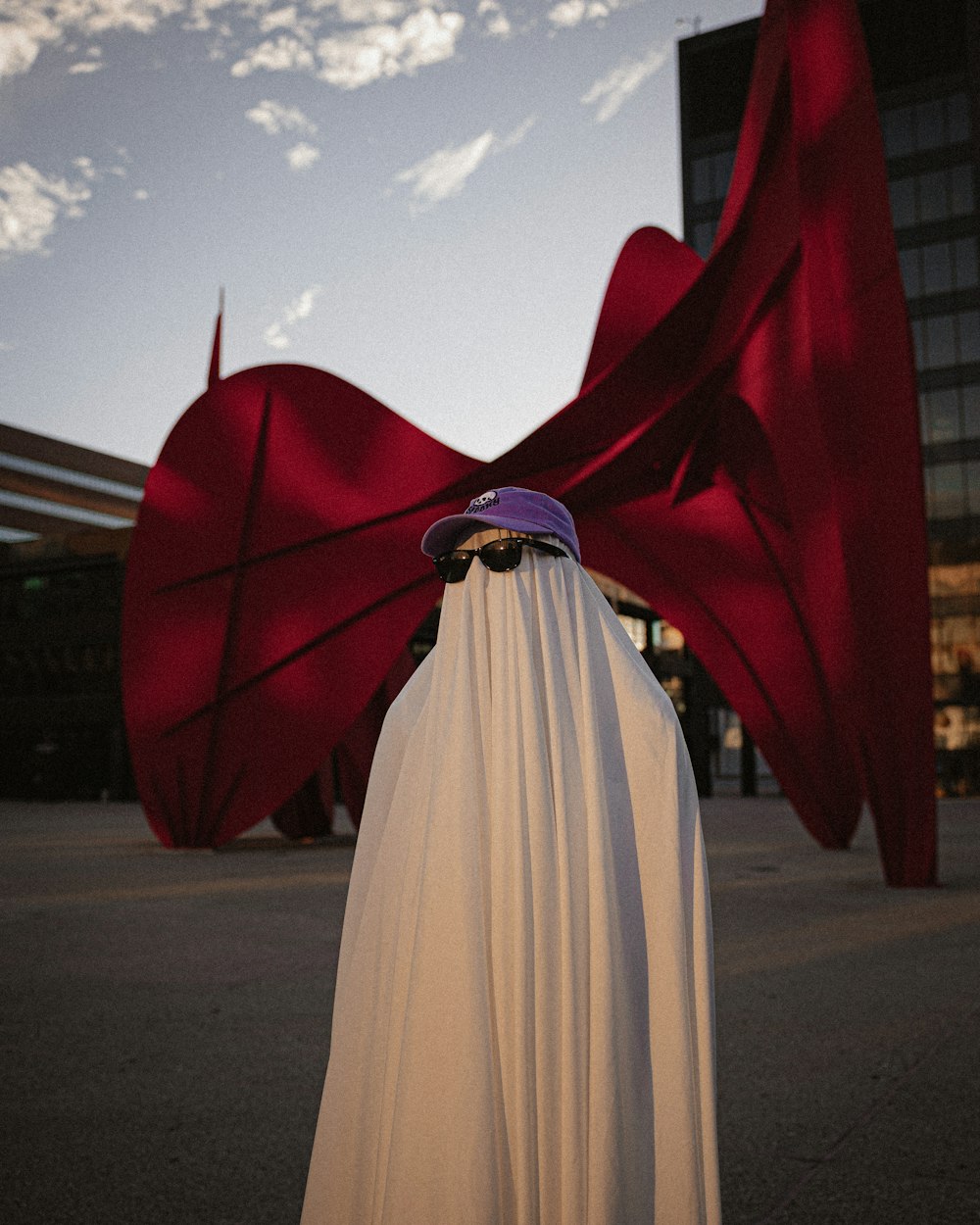 a man wearing a cape and a hat standing in front of a building