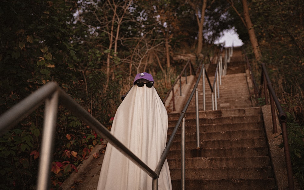 a woman in a white dress standing on a set of stairs