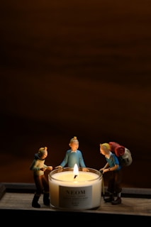 a candle with three figurines around it