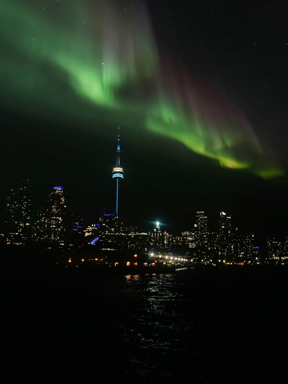 Die Aurora leuchtet nachts über der Skyline der Stadt