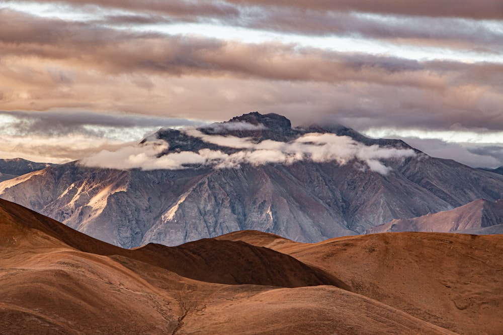 a mountain range with clouds in the sky