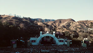 Wide shot of an outdoor event where Kevin performs with mountains in the background