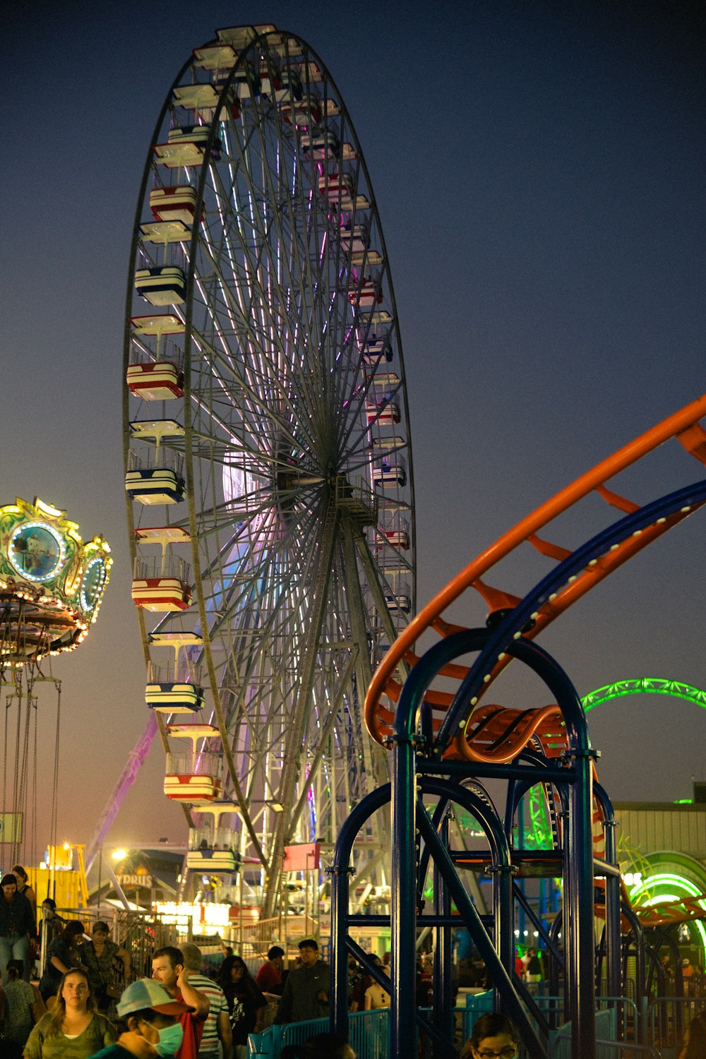 a large ferris wheel sitting next to a carnival ride