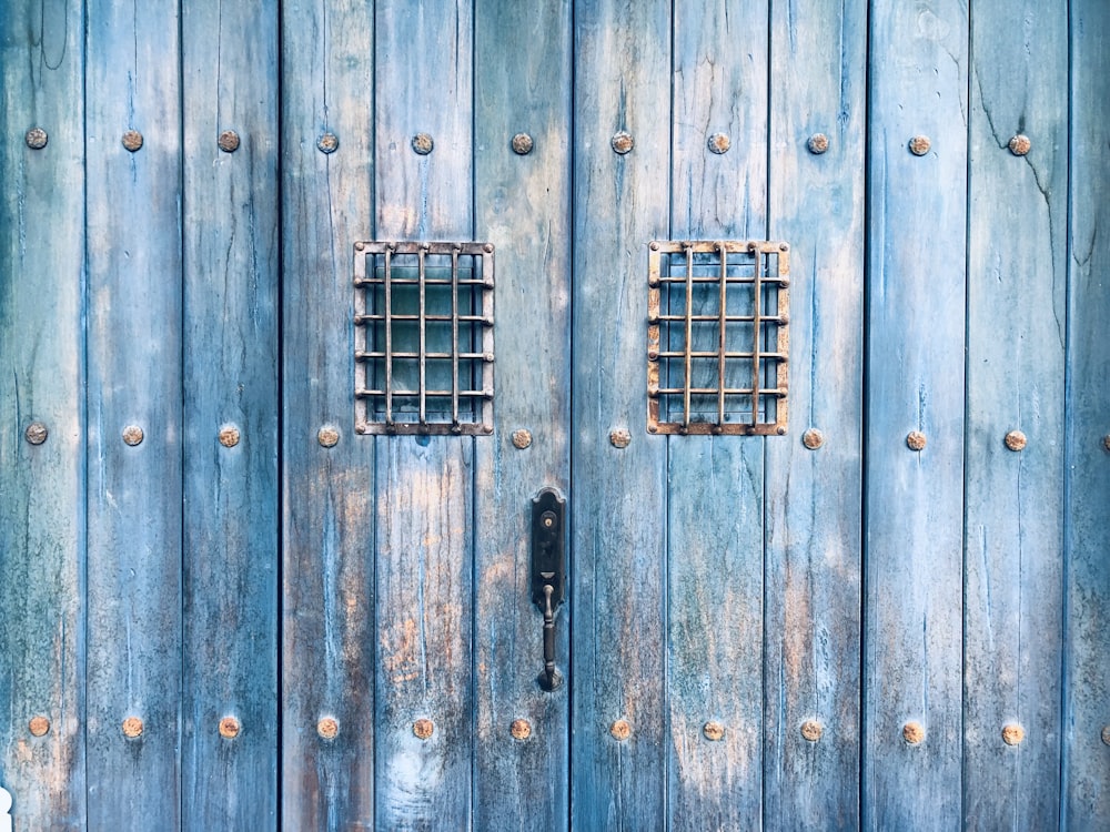 a close up of a wooden door with metal bars