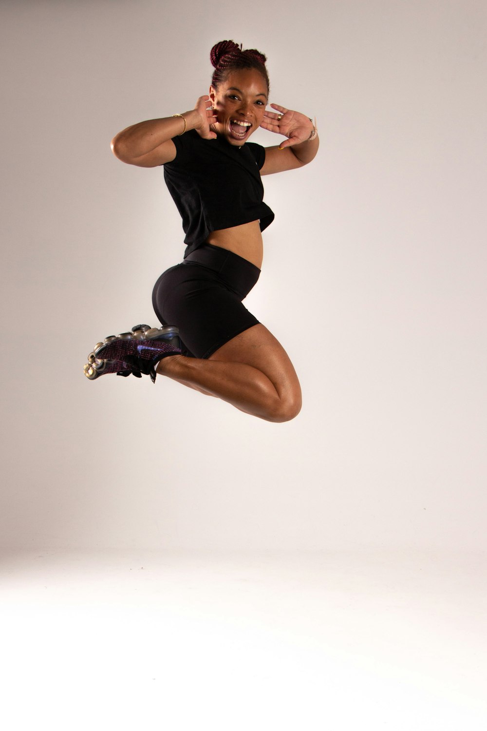 a woman jumping in the air with her hands on her hips