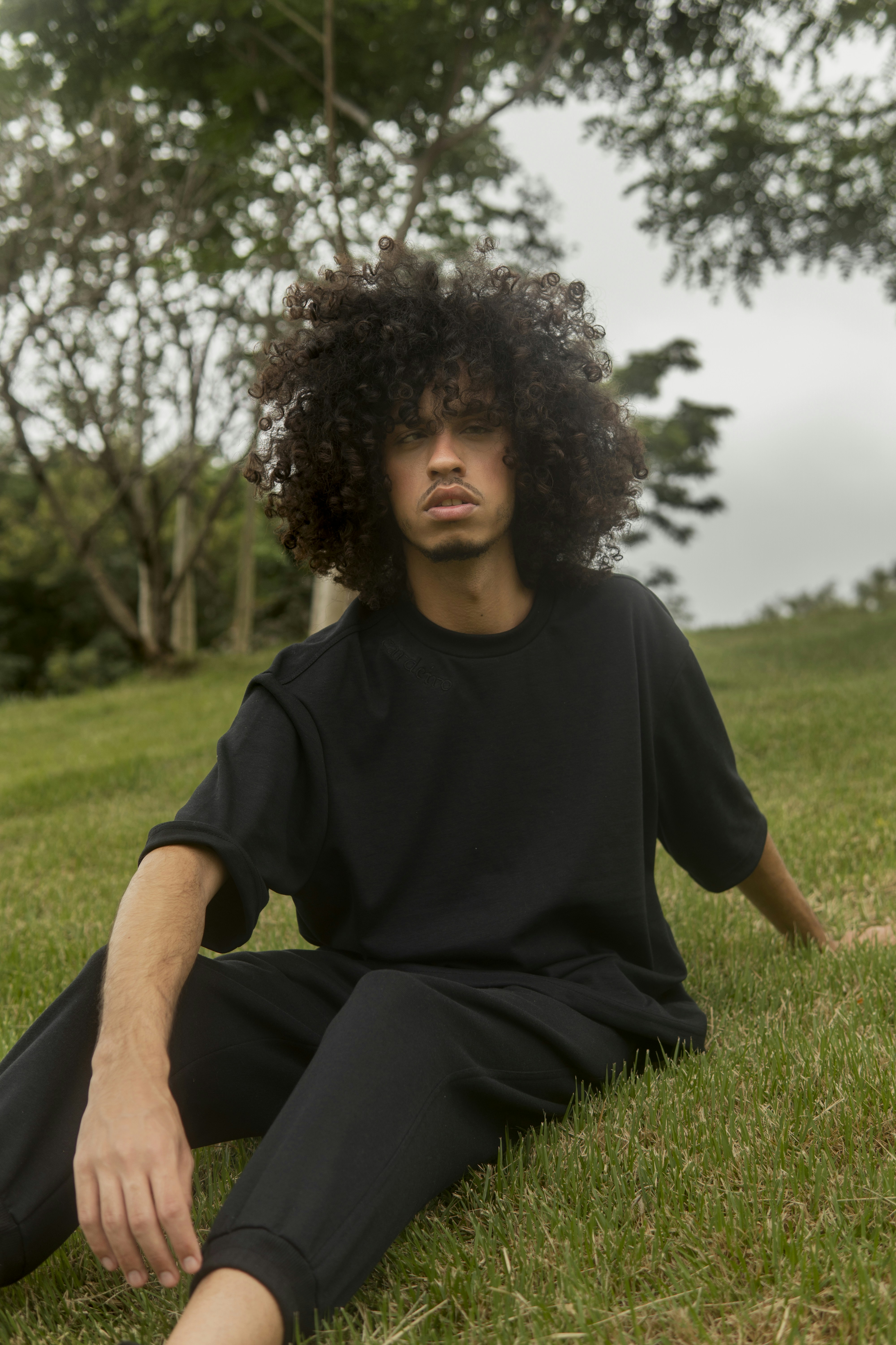 A man sitting in the grass with his legs crossed photo – Free Rio de ...