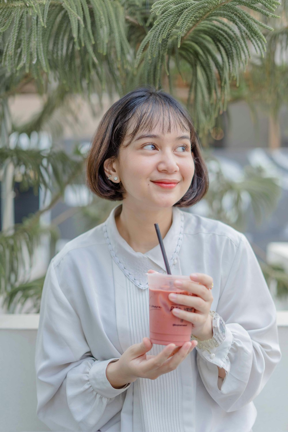 a woman is holding a drink and smiling