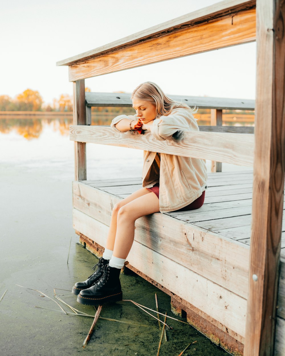 a woman sitting on a dock with her legs crossed