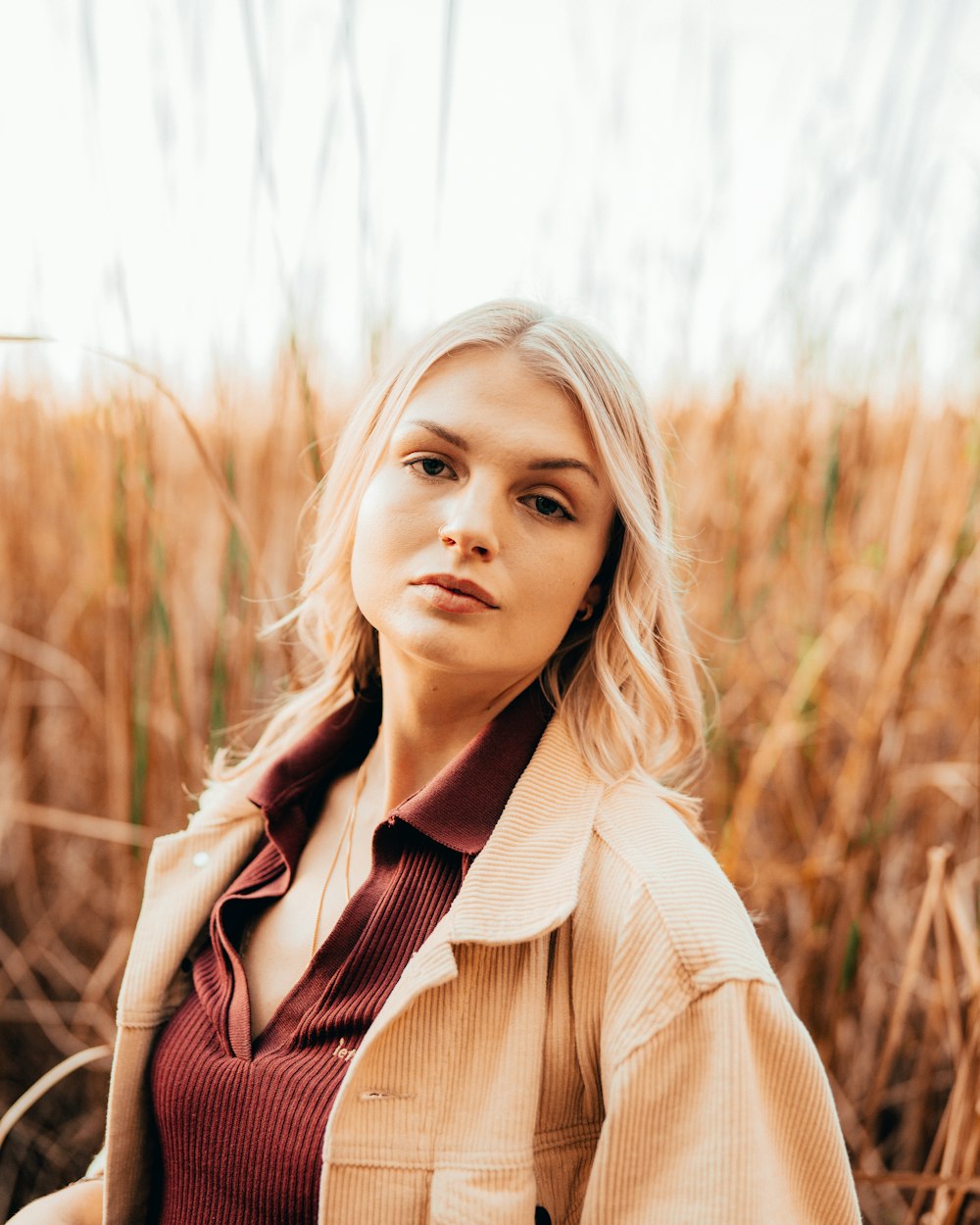 a woman standing in a field of tall grass