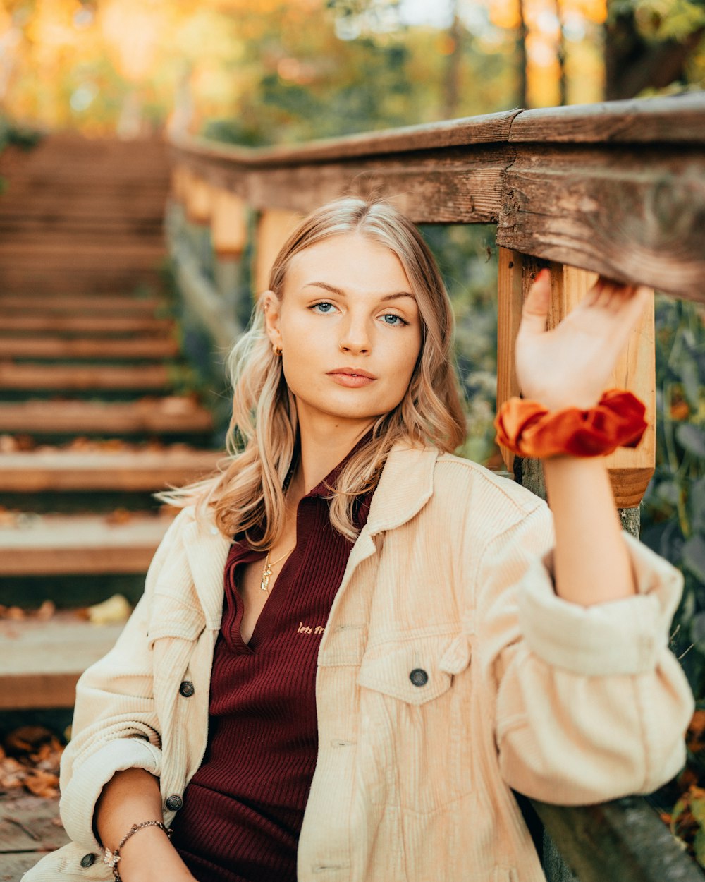 a woman sitting on a wooden bench in a park