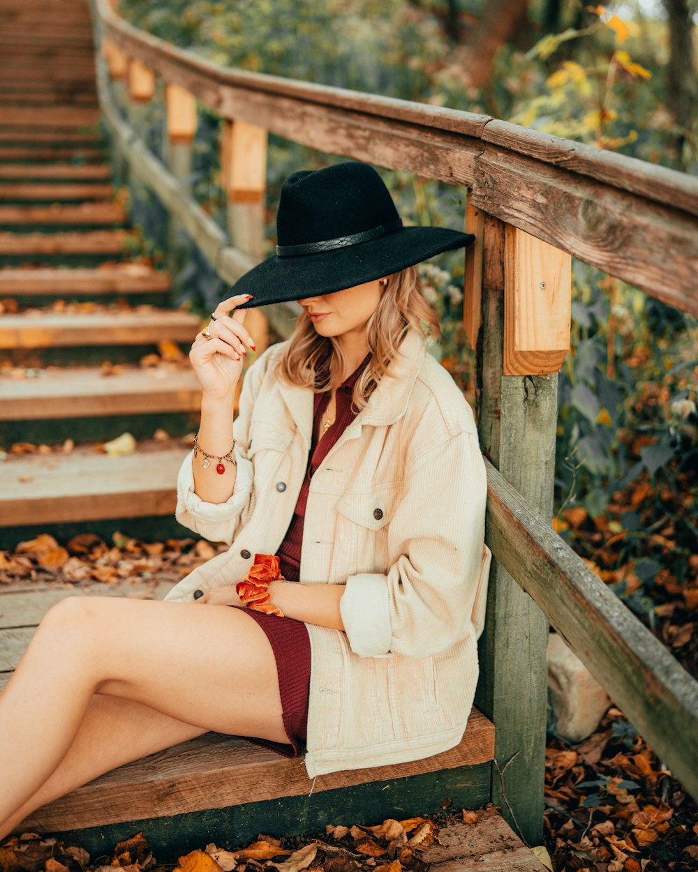 a woman in a hat sitting on steps