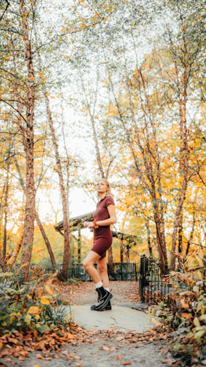 a woman running through a park in the fall
