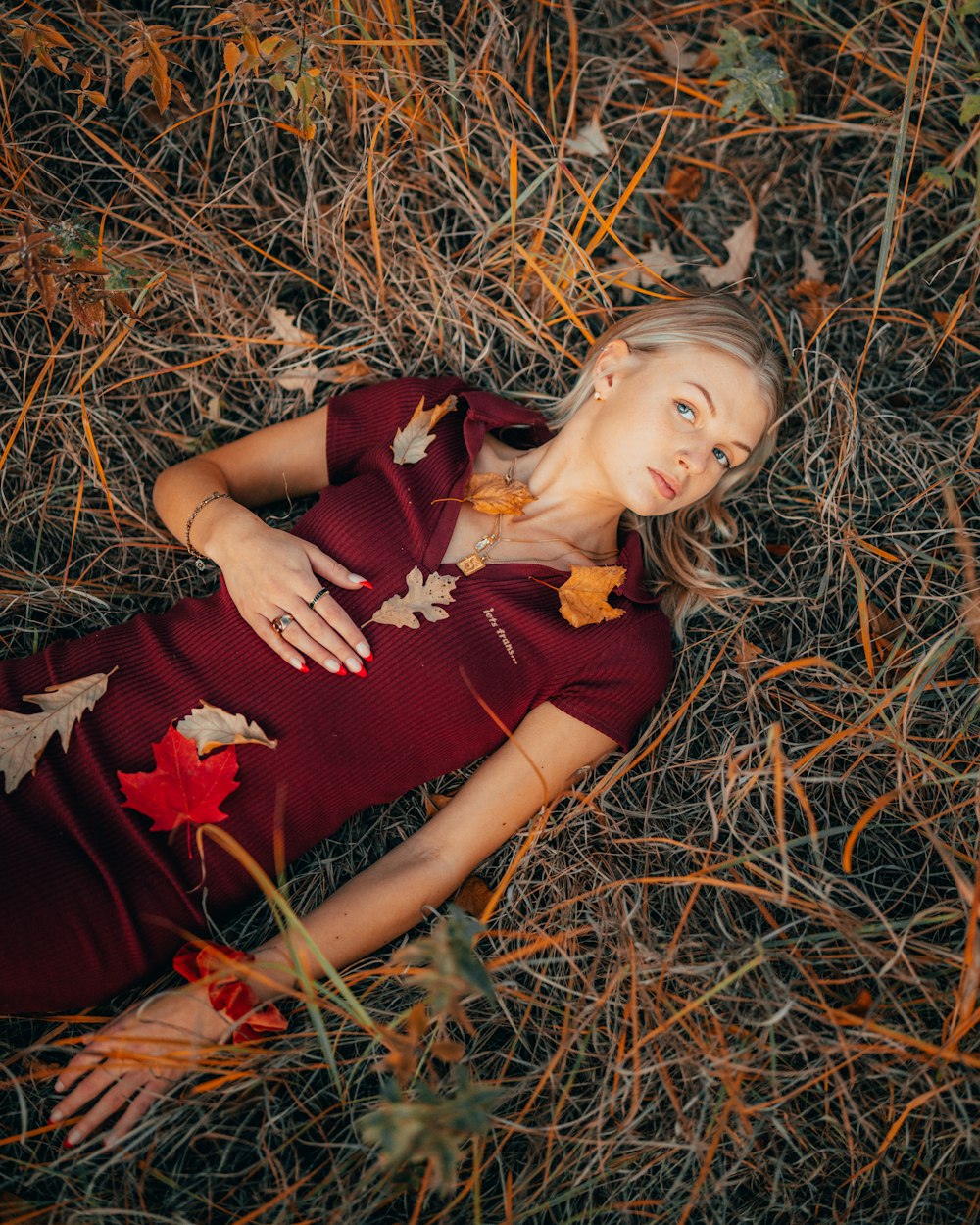 a woman in a red dress laying on the ground