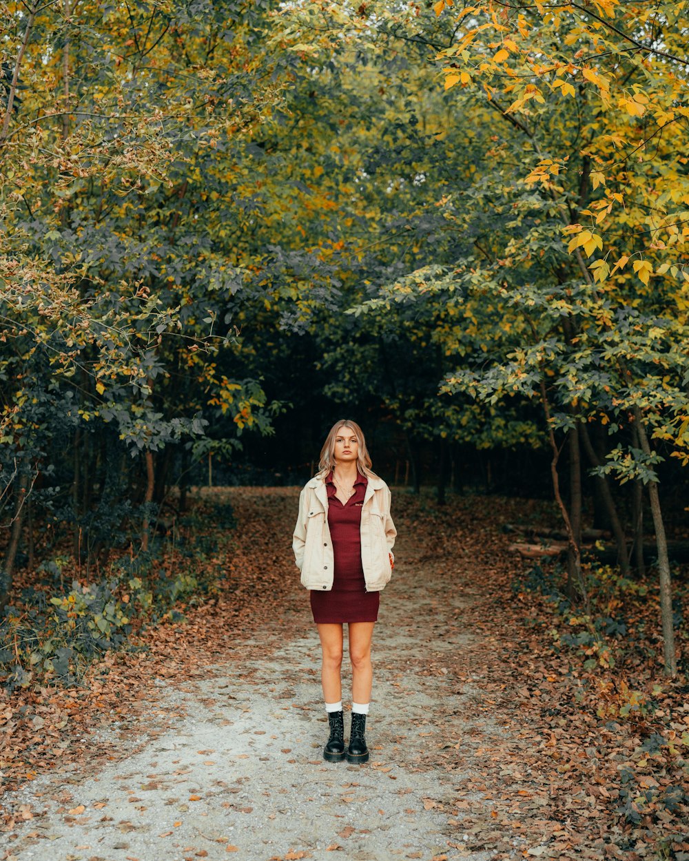 a woman standing in the middle of a forest