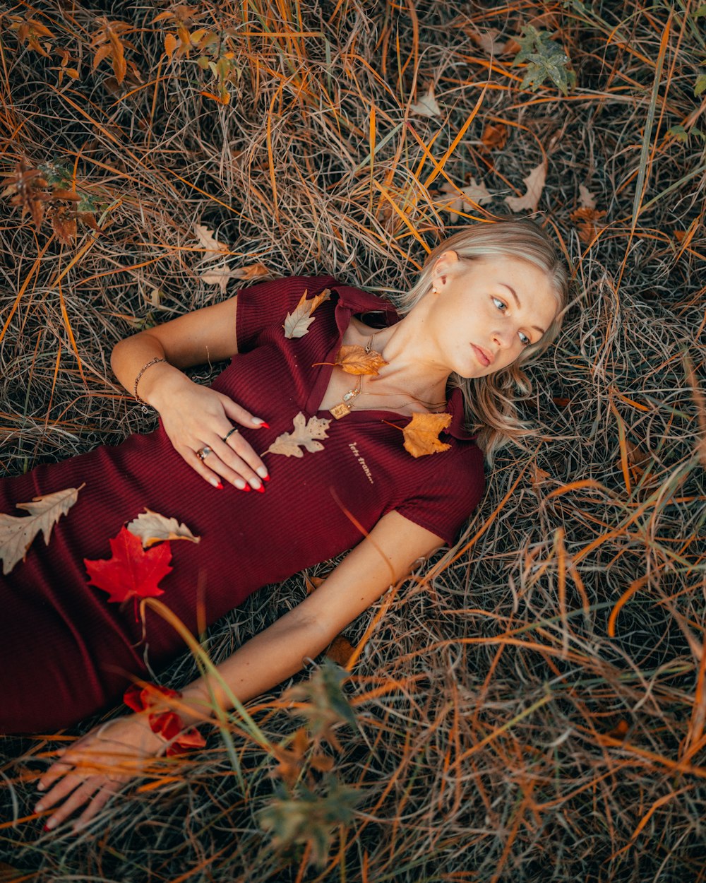 a woman in a red dress laying on the ground