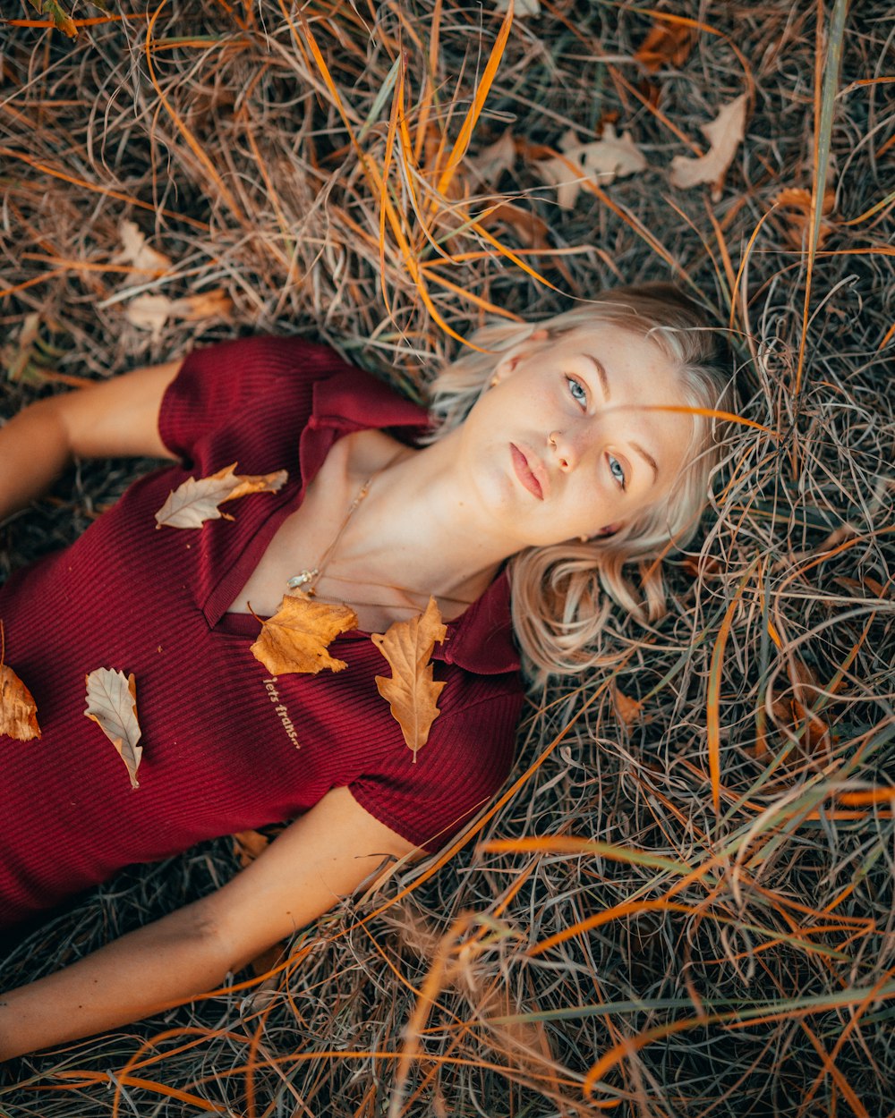 a woman in a red dress laying on the ground