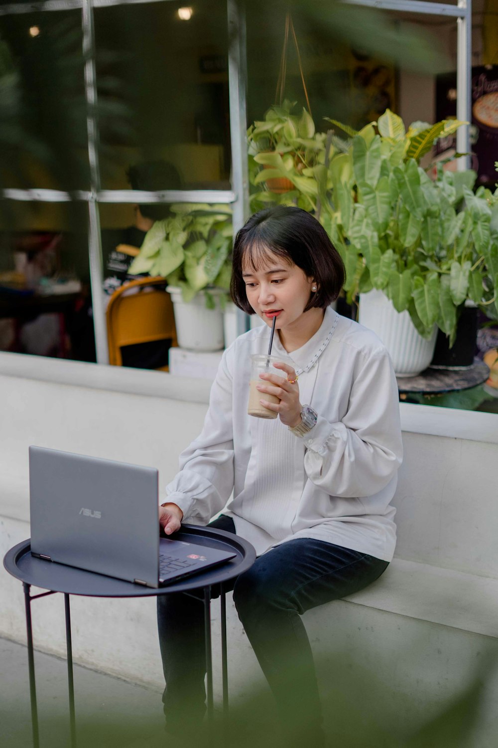 a woman sitting on a table using a laptop computer