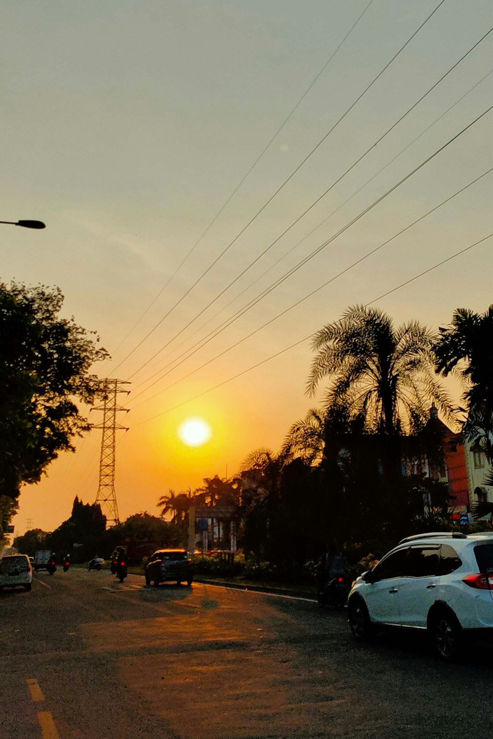 the sun is setting over a city street