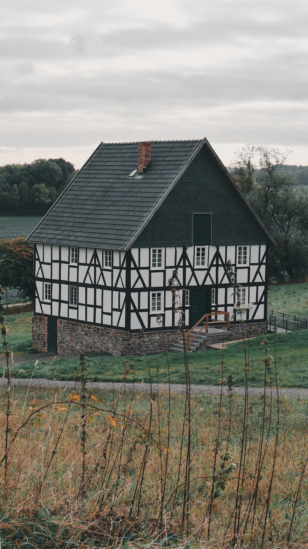 a black and white house sitting in the middle of a field