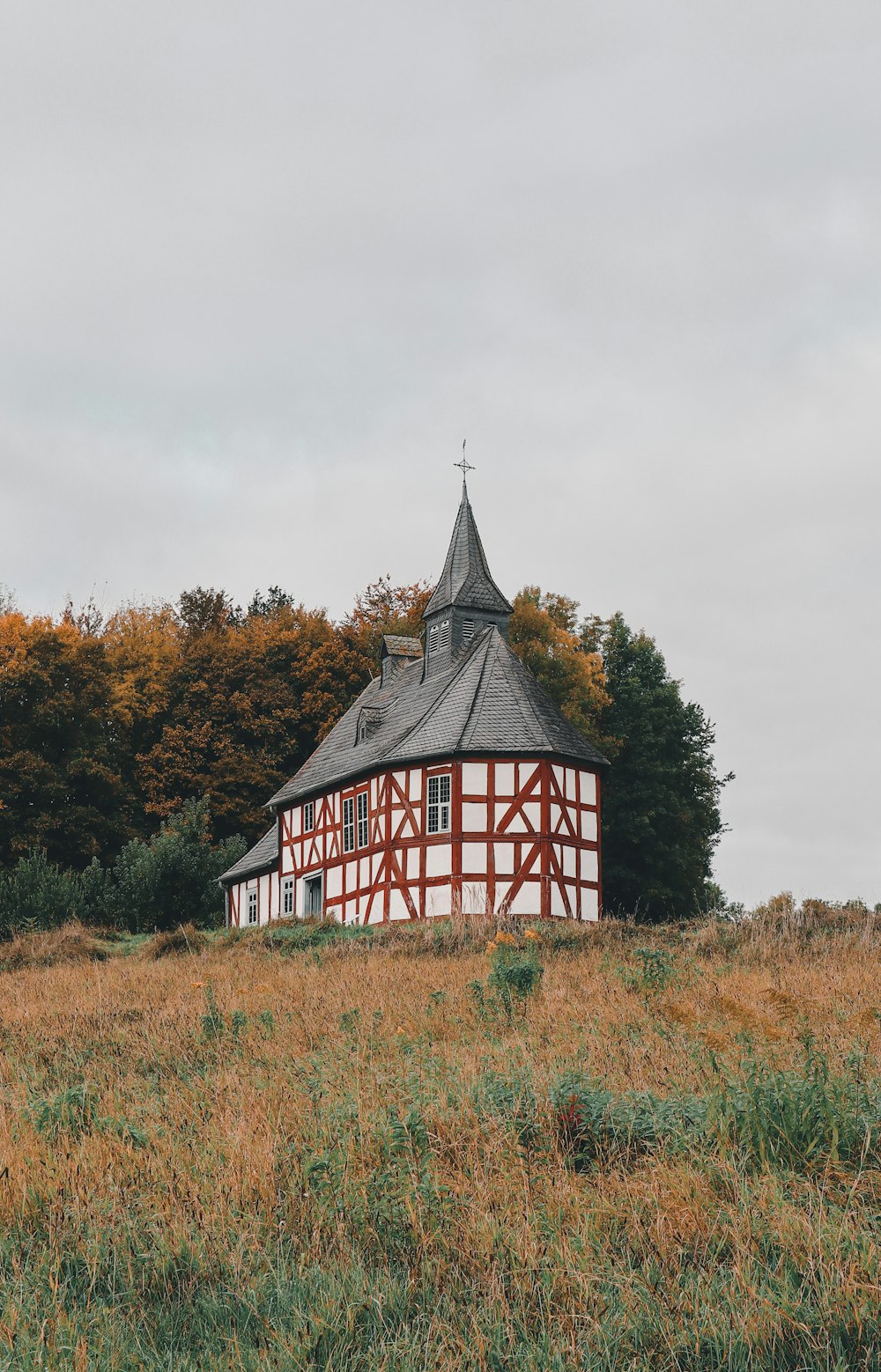 a red and white building sitting on top of a lush green field