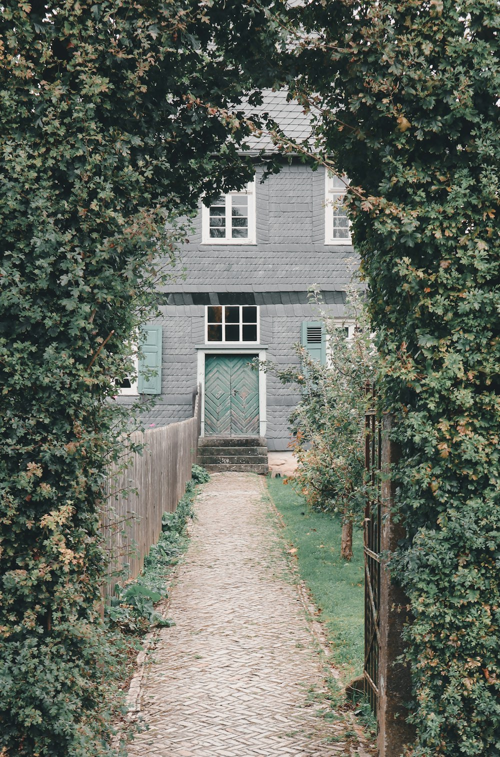 a stone path leading to a gray house