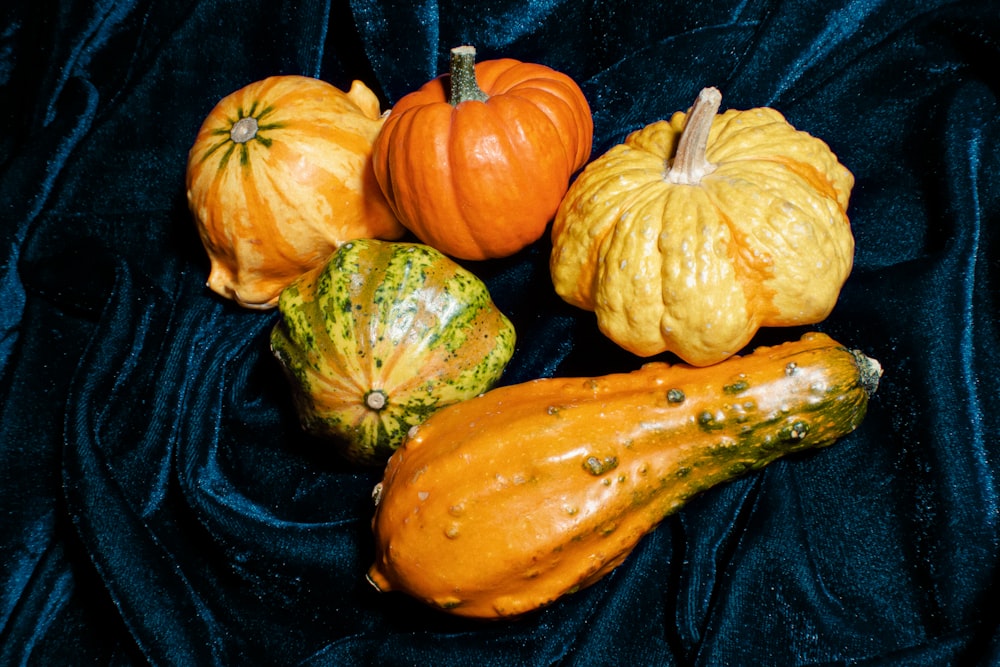 a group of pumpkins sitting on top of a blue cloth