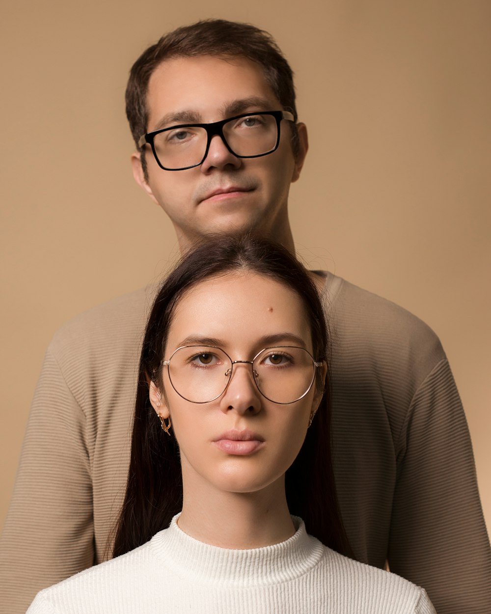 um homem e uma mulher com óculos de pé um ao lado do outro