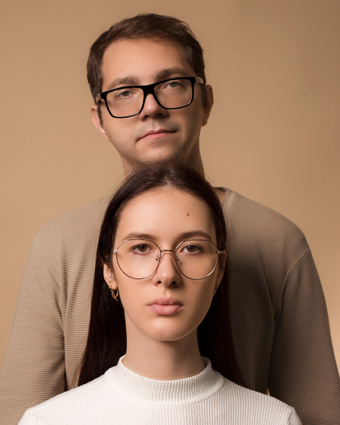 Couple with glasses standing together in a portrait showing how glasses-wearers can be photographed naturally without glare when the angle between camera light source and glasses lens is correctly managed